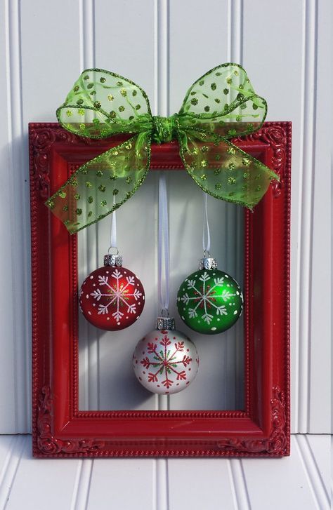 a red frame with christmas ornaments hanging from it