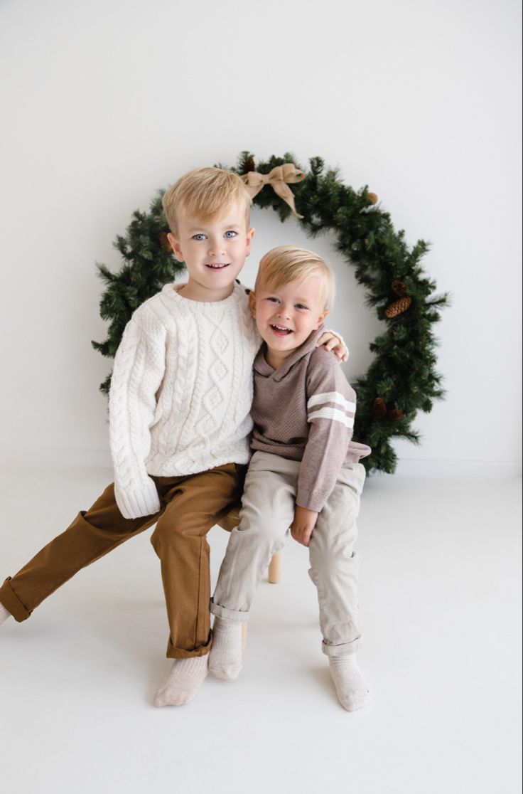 Brothers sitting together smiling during photoshoot Natal, Sibling Christmas Photoshoot Ideas, Kids Christmas Photoshoot Outfits, Christmas Photo Shoot Toddler, Christmas Photos Siblings, Kid Christmas Photoshoot, Christmas Kids Photoshoot Ideas, Sibling Christmas Photoshoot, Brothers Christmas Photos