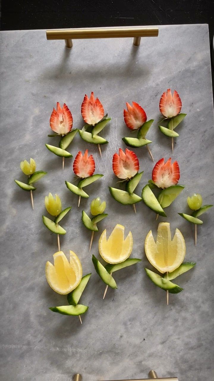 flowers and lemon slices are arranged on a sheet of paper with toothpicks attached to them