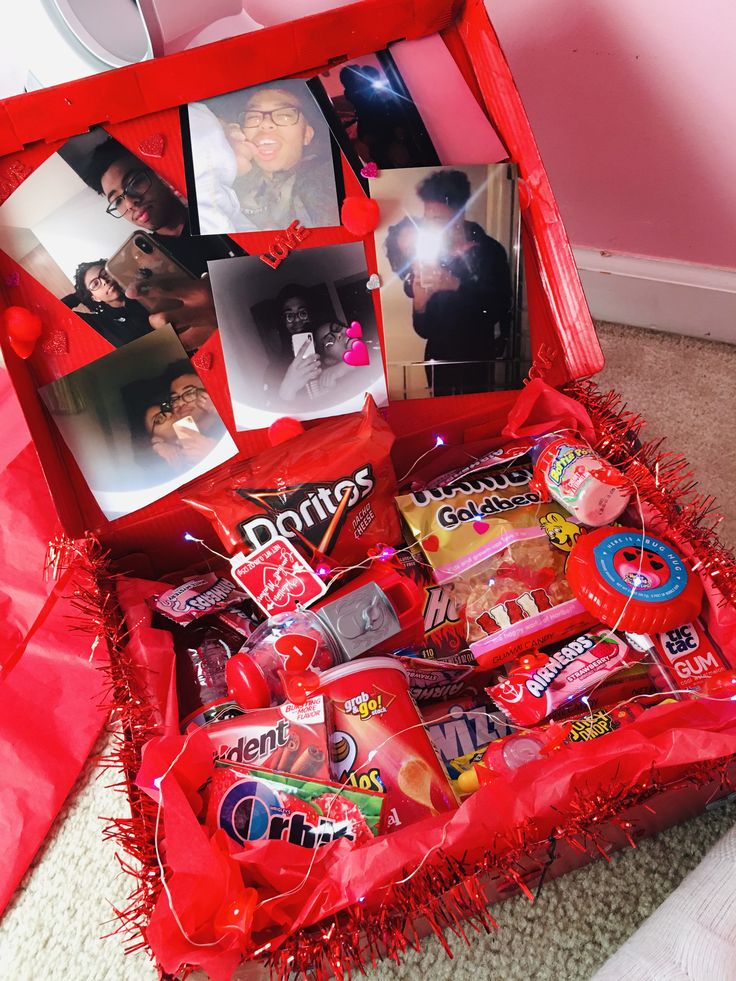 an open red box filled with candy and candies on top of a carpeted floor