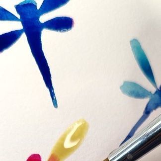 some watercolors are being used to paint dragonflies