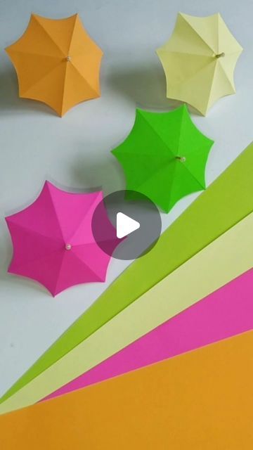 an array of different colored umbrellas sitting on top of a white table next to each other