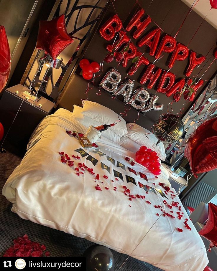 a bedroom decorated with balloons and streamers for a happy birthday party in the shape of a bed