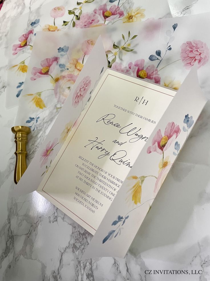 the wedding stationery is laid out on top of the marble countertop with flowers