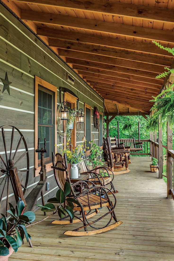 a porch with rocking chairs and plants on it