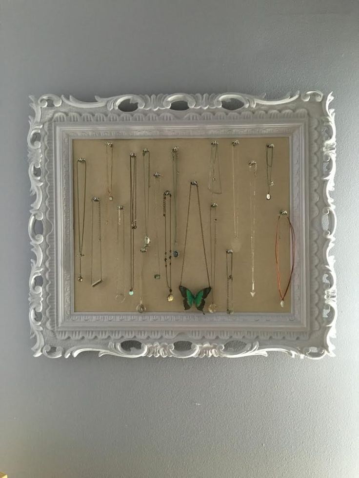 a white frame with jewelry hanging on it