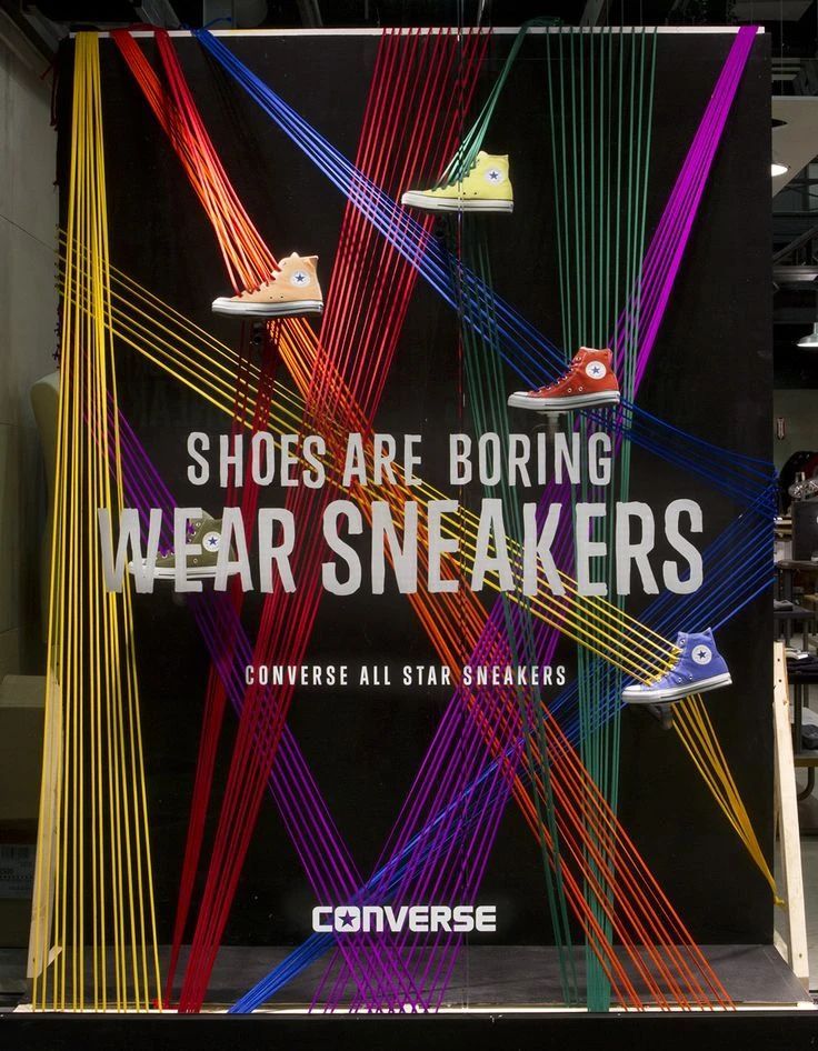 an advertisement for shoes are boring wear sneakers on display in a storefront window