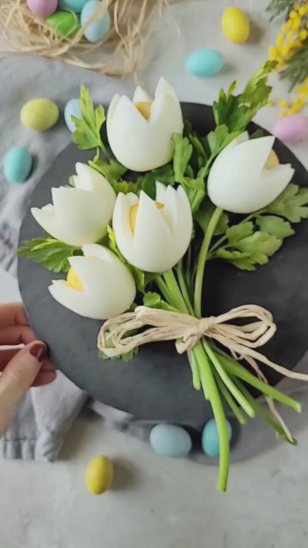 This may contain: a bouquet of white tulips tied with twine on a black platter