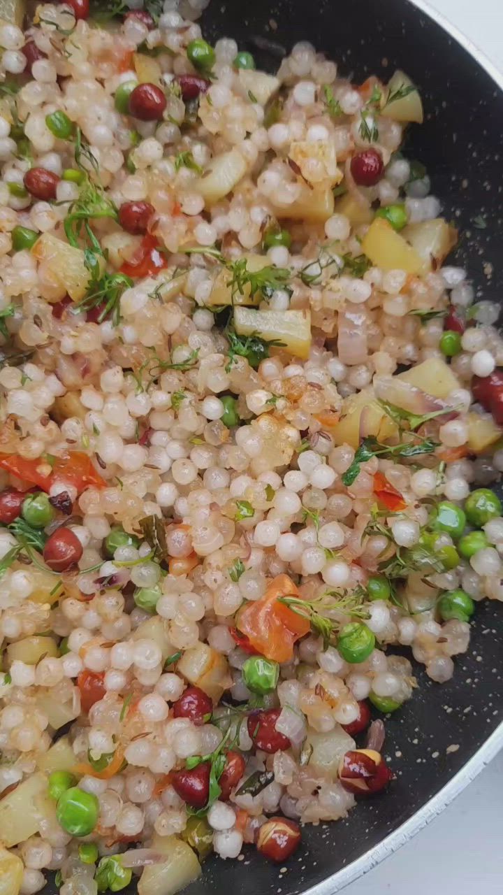 This may contain: a pan filled with rice and vegetables on top of a stove