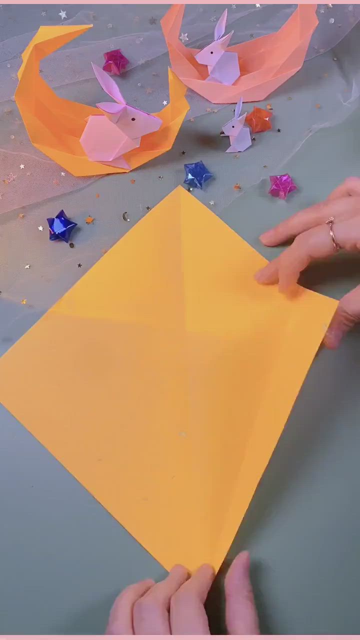 This may contain: two hands are holding up origami pieces