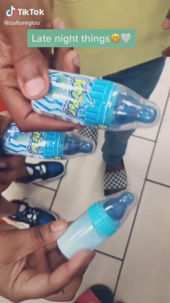 This may contain: someone is holding two baby bottles in their hands while another person holds the bottle with one hand