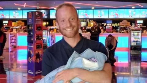 Dad Gareth holding his newborn daughter