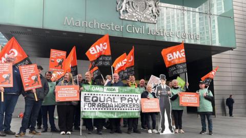 Protesters gather outside Manchester Civil Justice Centre to wave GMB flags at the start of the case