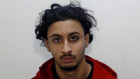 Police mugshot of Muhammad Zakir Arif wearing a red hoody over a black T-shirt