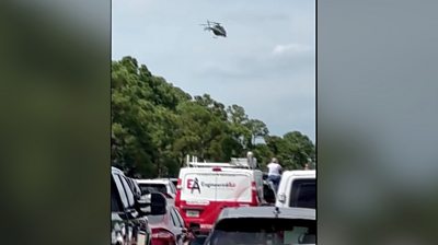 Lines of cars in traffic with helicopter flying overhead