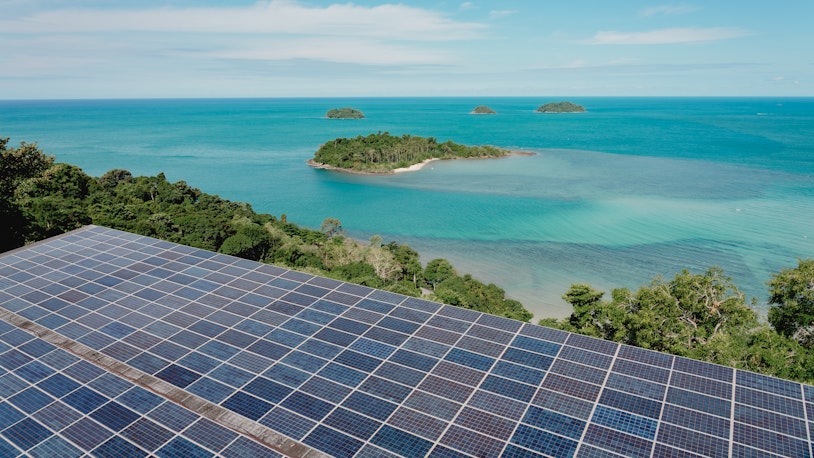 Photo shows Aerial top view of solar panels or solar cells on sea or ocean view. Power plant with water, renewable energy source. Eco technology for electric power in industry.