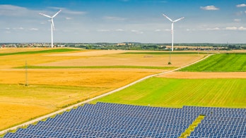 Solar panels and wind turbines in a field, cover of Renewables 2021