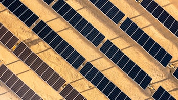 Photo depicts aerial Sunrise View over Solar Panels in Palm Springs California