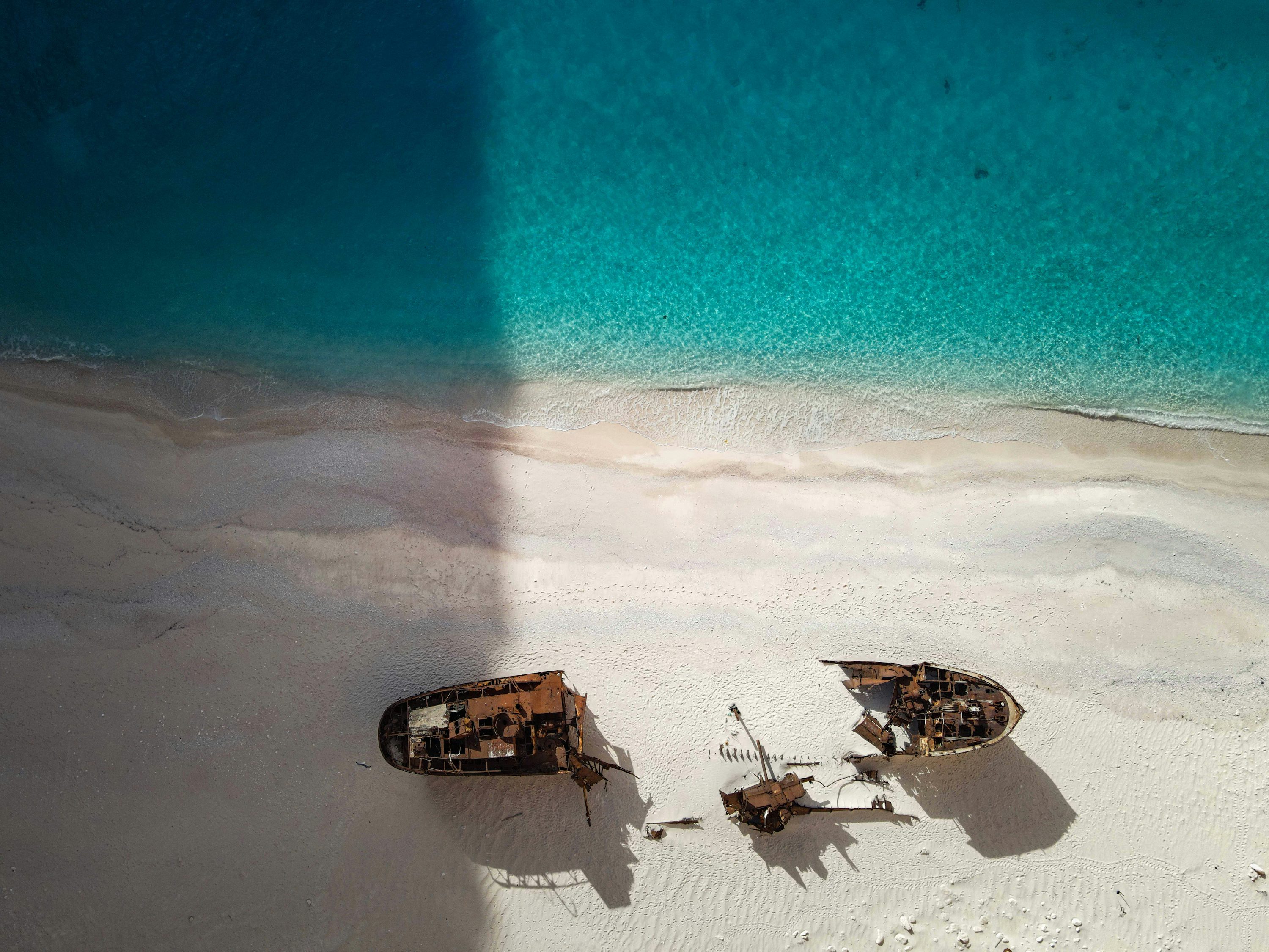 A couple of boats sitting on top of a sandy beach