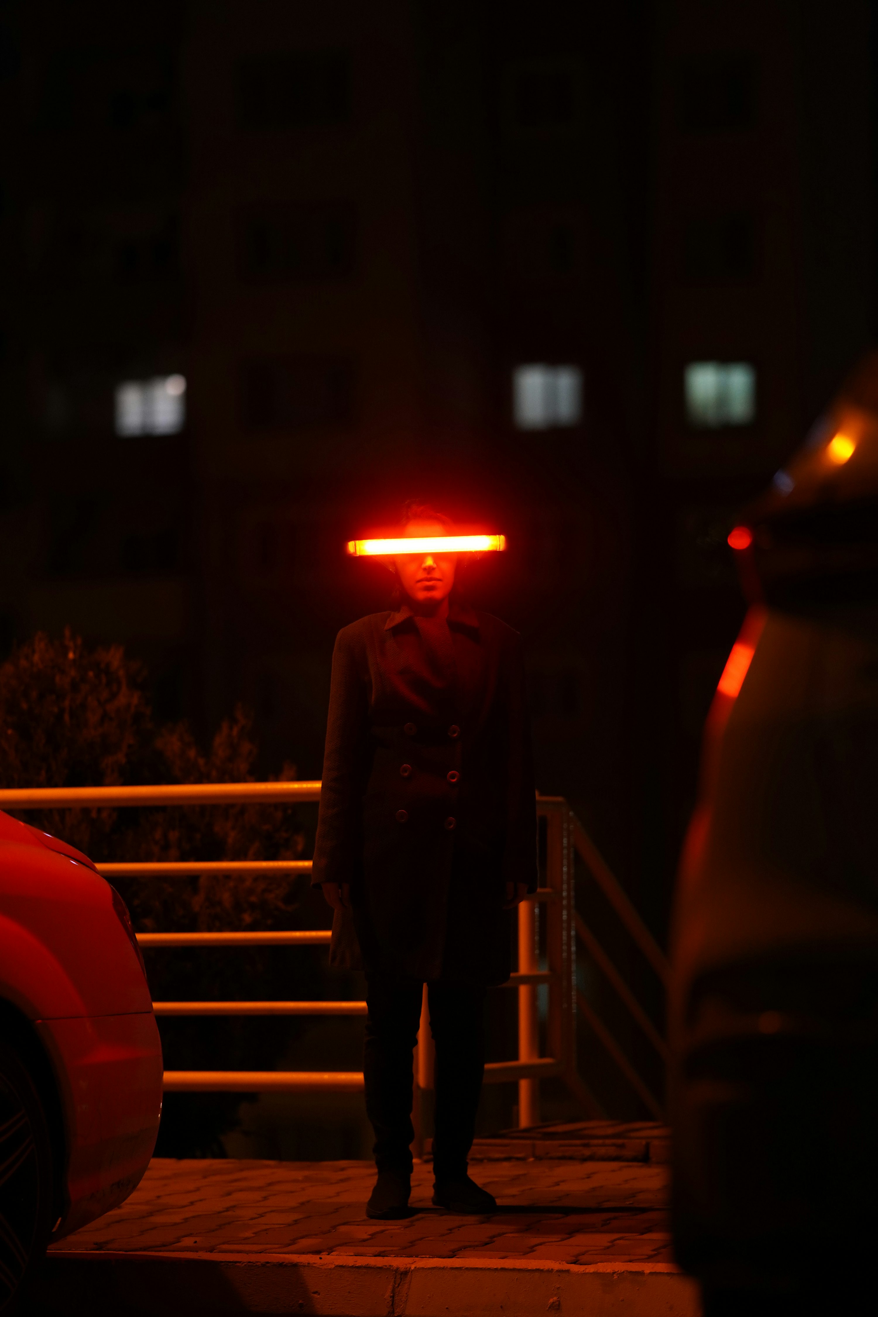 A person standing in the dark with a red light on their head