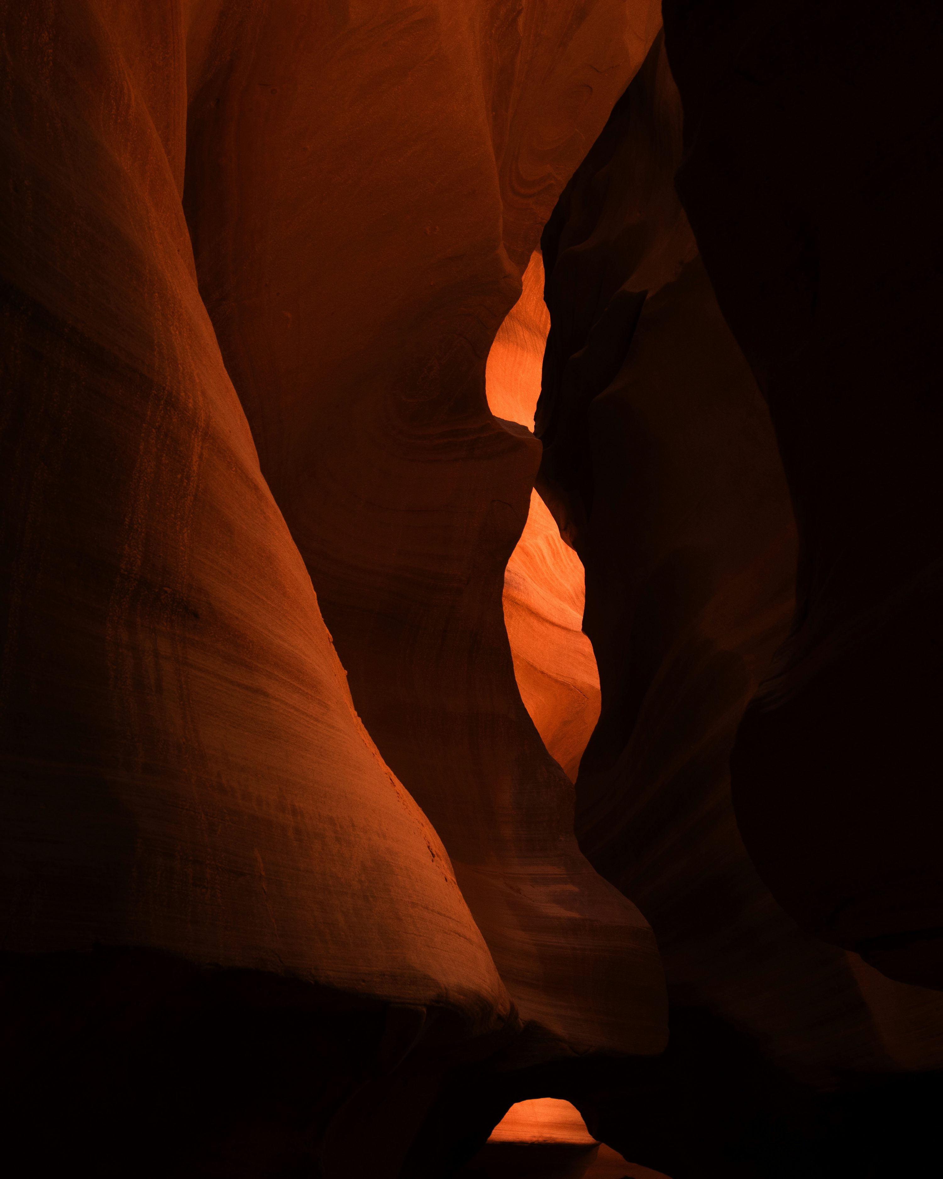 A person standing in a narrow slot in a canyon