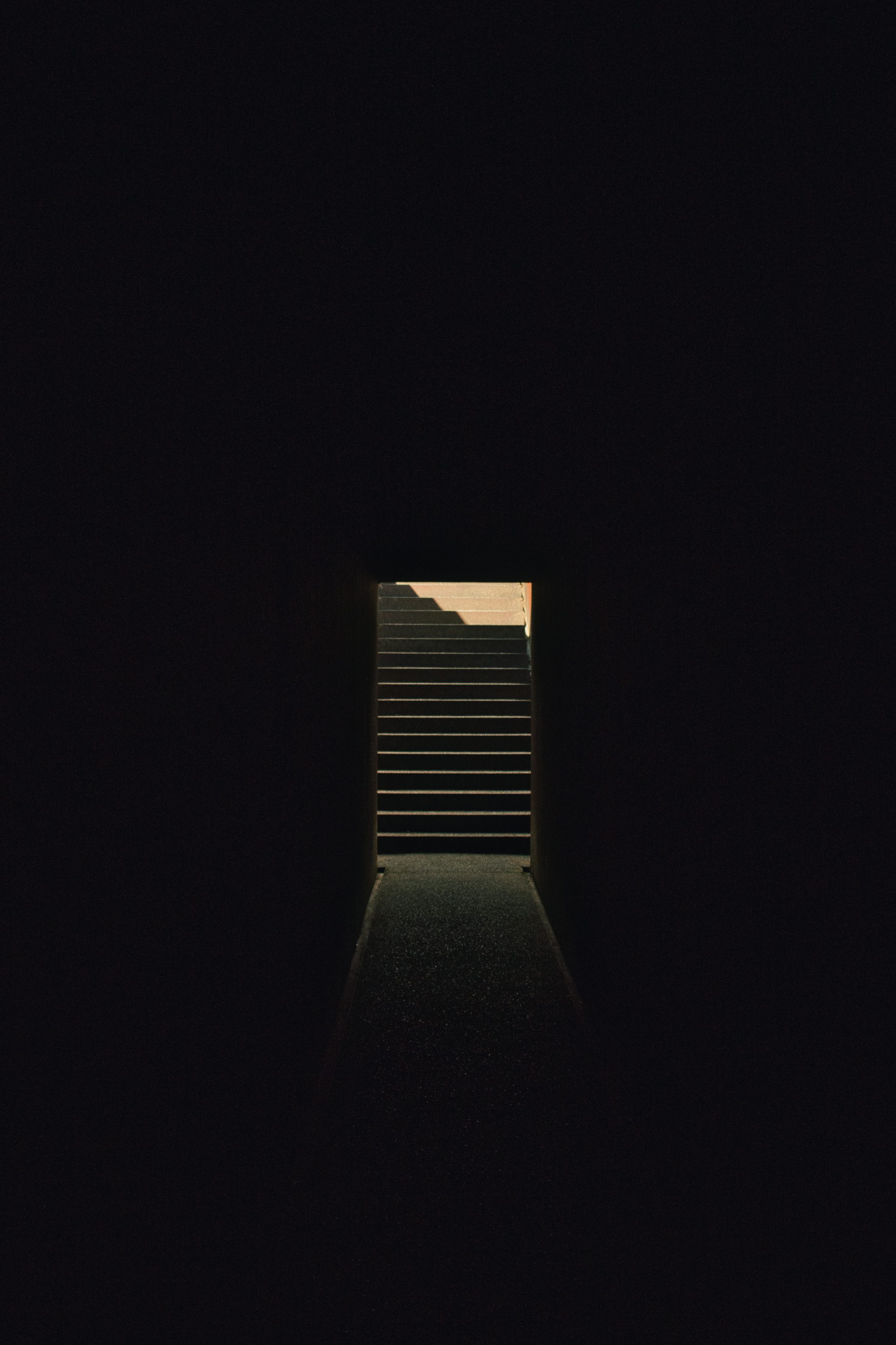 A dark tunnel with a stairway leading to the sky