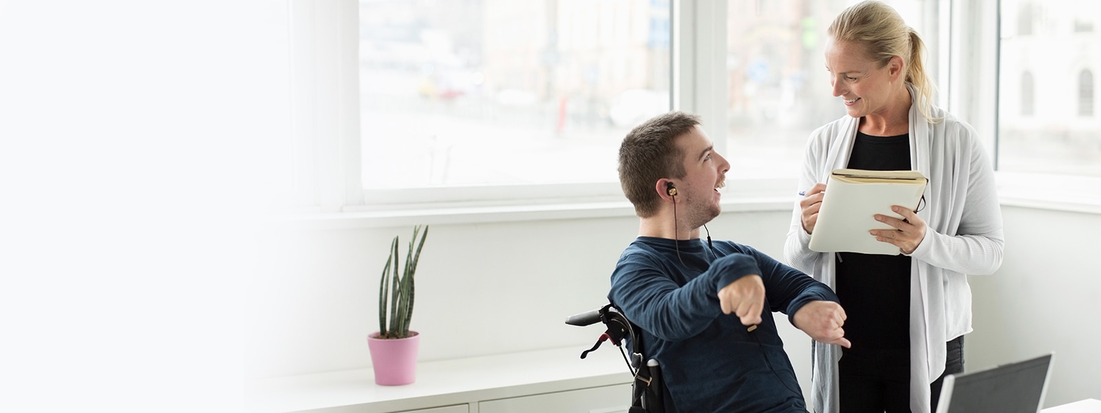 Disabled businessman discussing work with colleague in office.