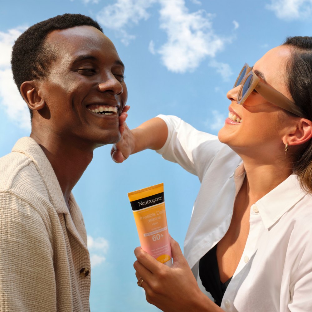 Man and woman applying sunscreen