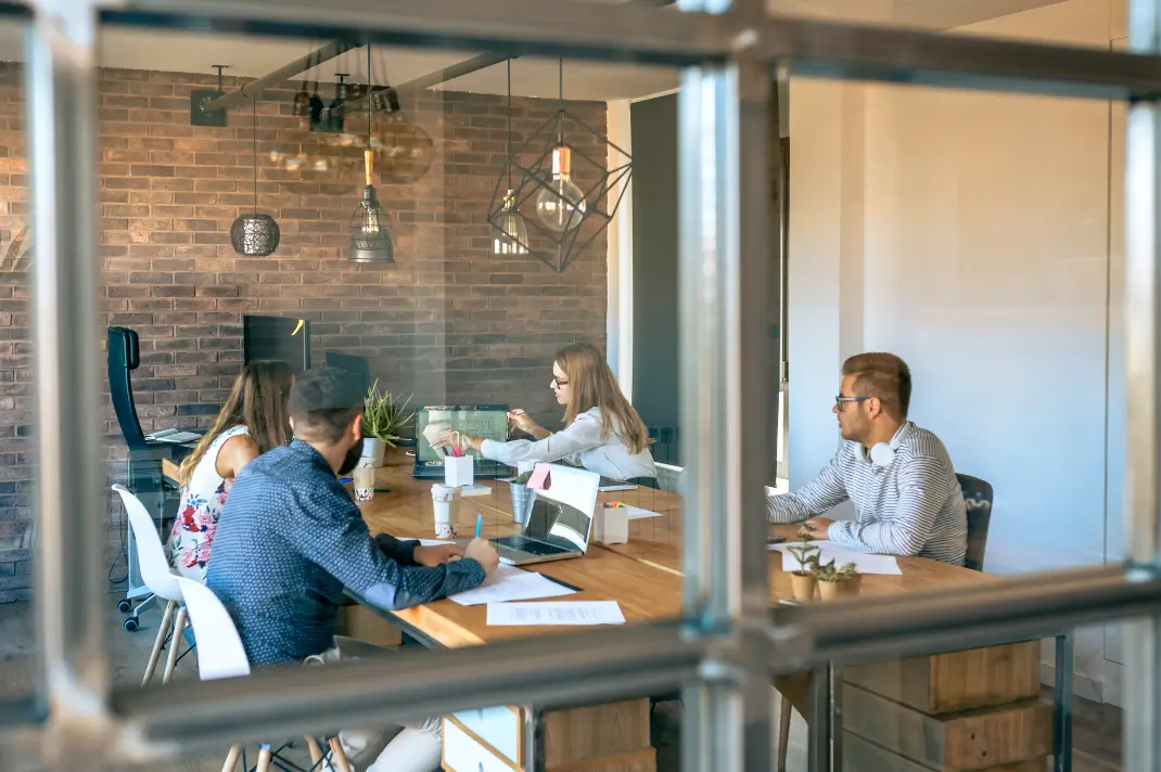 Image of a group of people sitting at a table collaborating