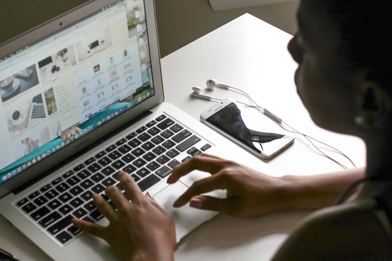 a woman working away, typing on her laptop keyboard