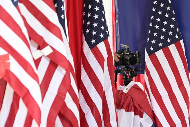 A videocamera surrounded by U.S. flags