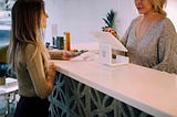 A customer and cashier at a store checkout counter