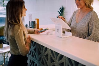 A customer and cashier at a store checkout counter