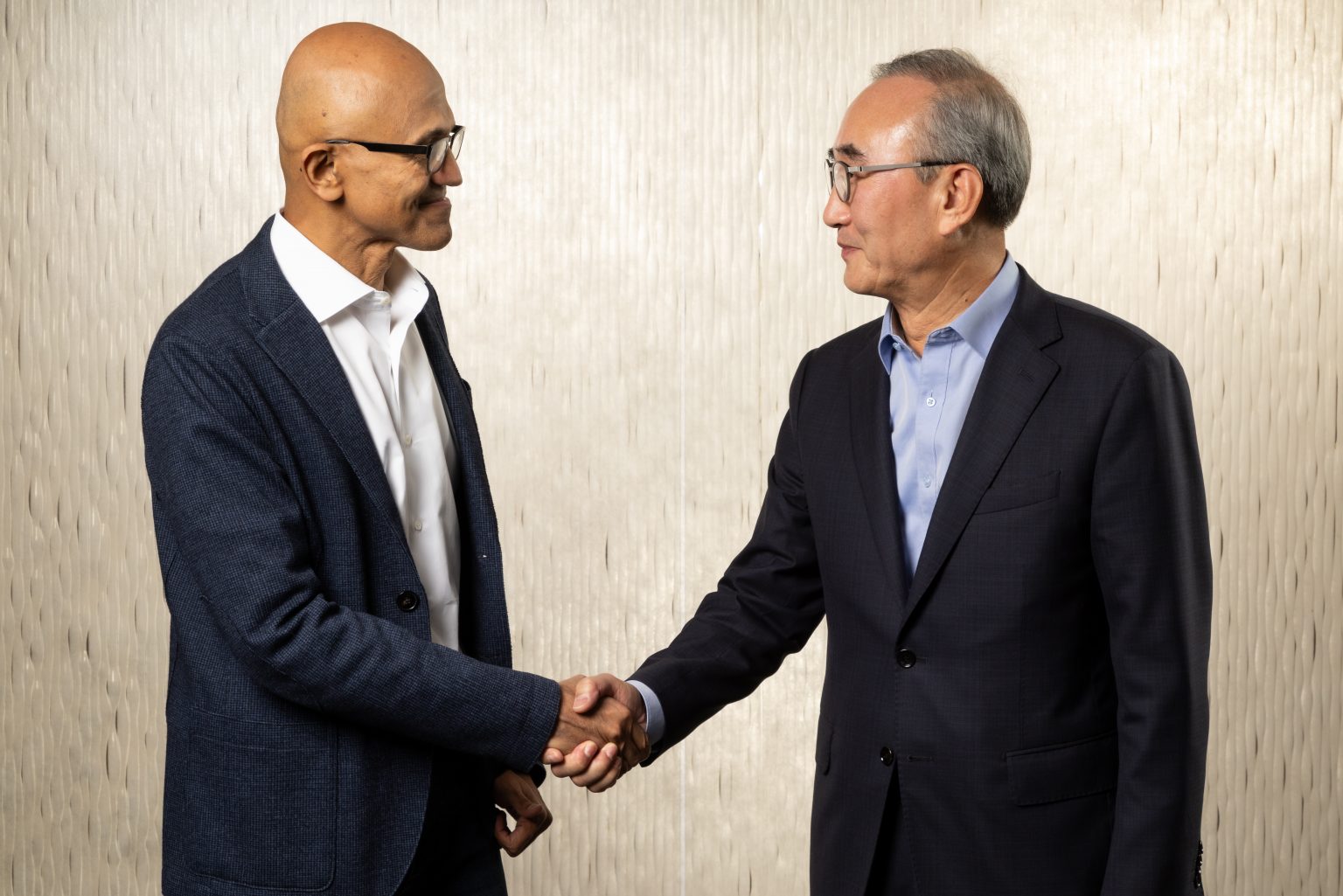 two men in formal attire shaking hands