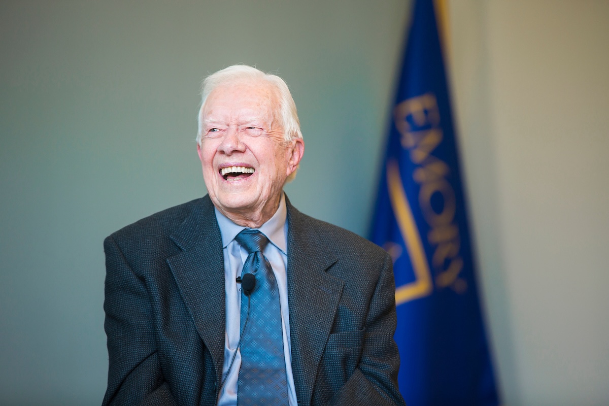 president carter in front of Emory flag