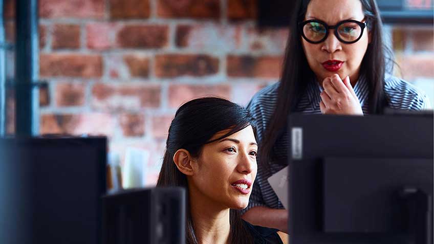 Two women looking at a computer display in the office