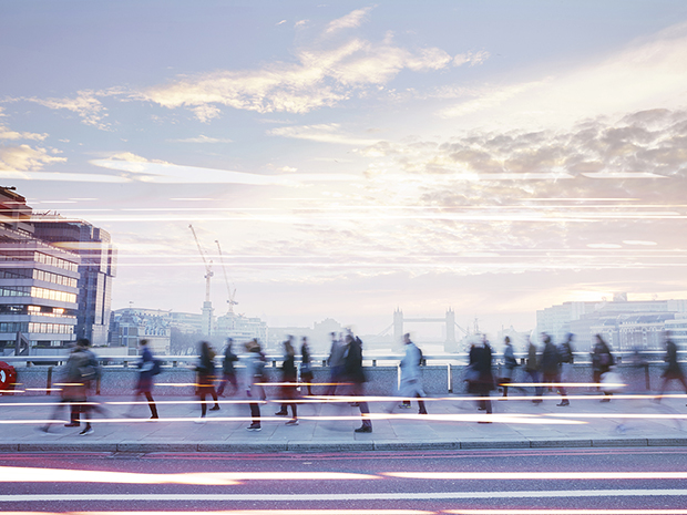 Pedestrians walking across a bridge during their morning commute.