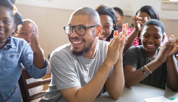 A smiling community group applauds