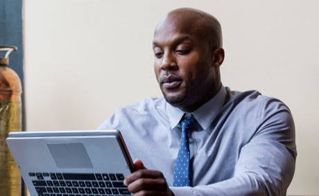 Man sitting at a desk working on a laptop