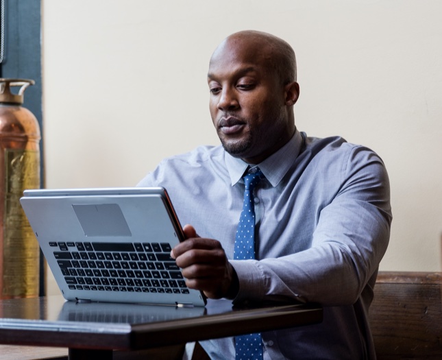 Man sitting at a desk working on a laptop