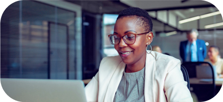 A person smiling while typing on a laptop