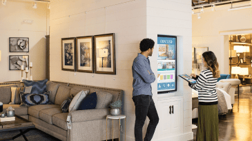 Woman operating a digital display while a man observes