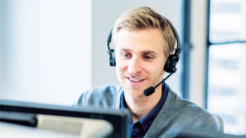 Person wearing a headset working on a computer