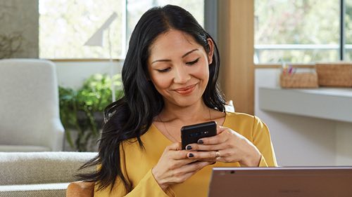 Person smiling holding a mobile phone