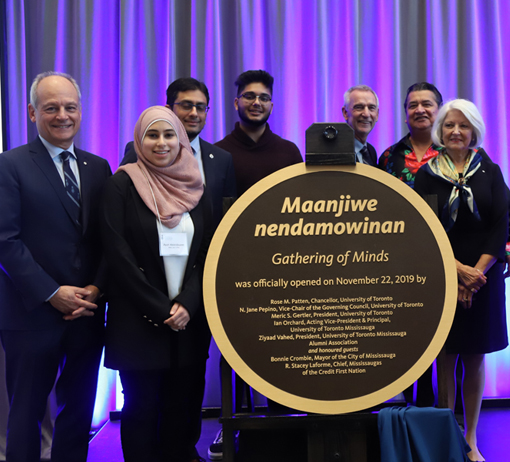 Meric Gertler and group stand by a newly unveiled plaque. Text on plaque reads, Maanjiwe nendamowinan, gathering of minds.