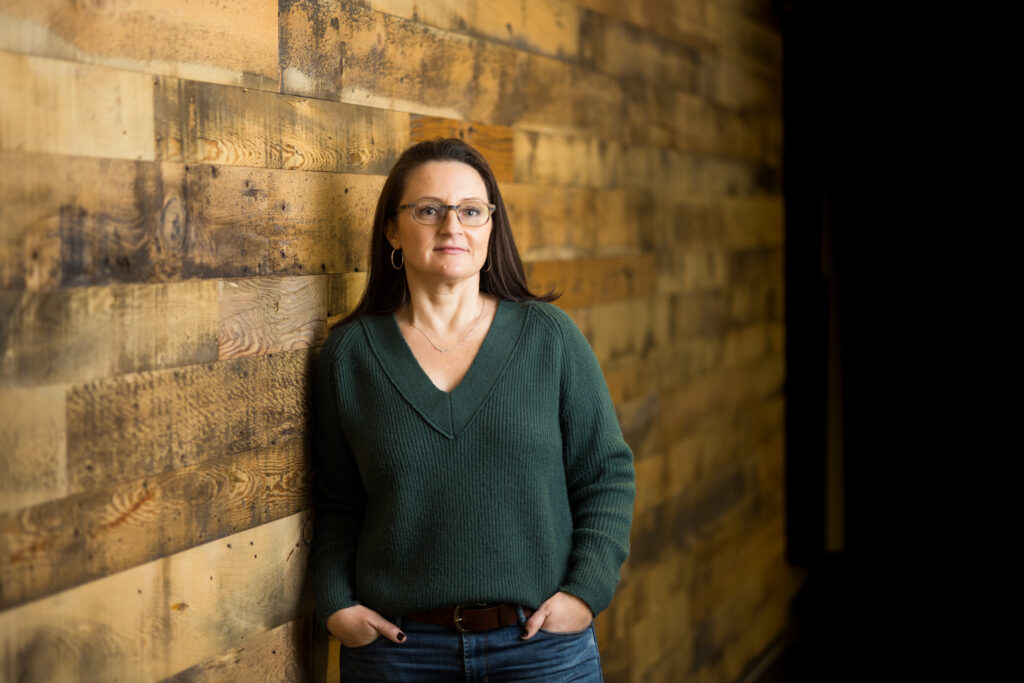 Woman stands next to a wall