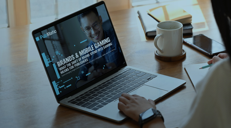 A person typing on a laptop with a screen showing the cover report titled, "Navigating Commerce Media 2.0: Market Opportunity"