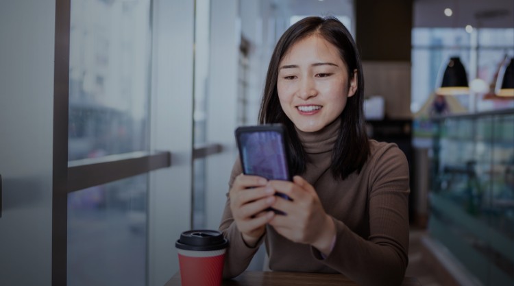 Young Asian woman using smart phone in coffee shop