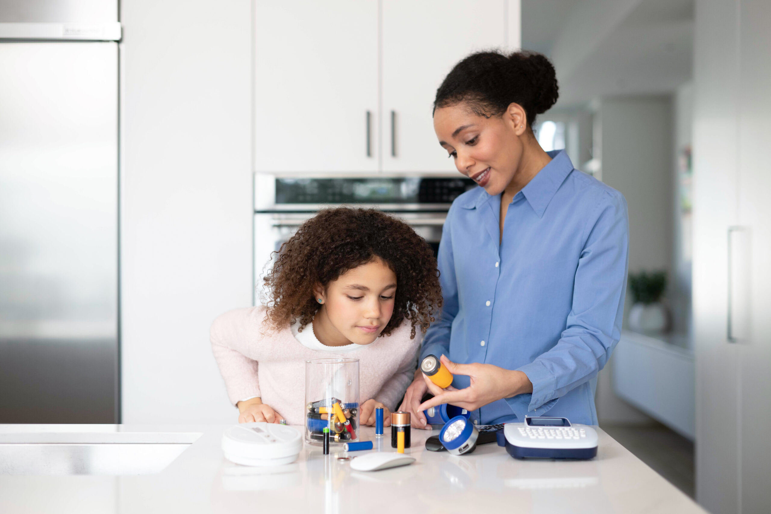 mom teaching child about battery recycling