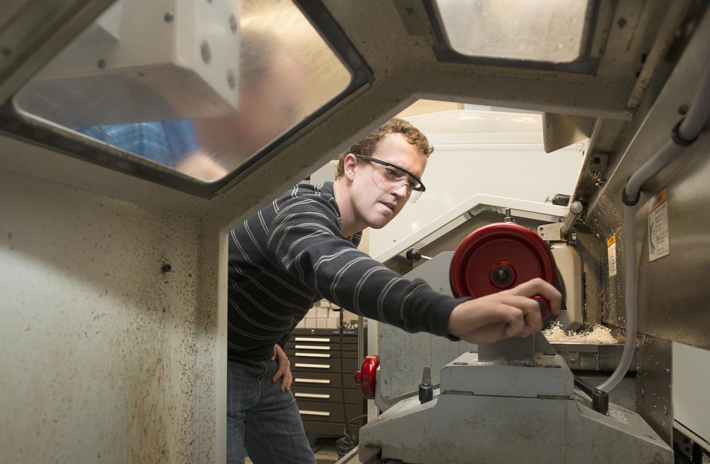 MIT student in lab with goggles. 